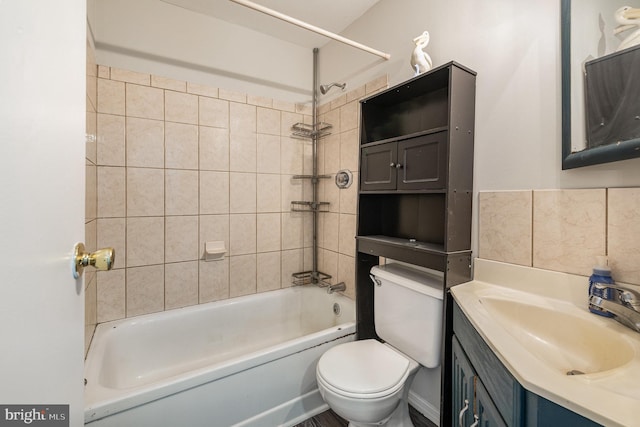 full bathroom featuring tasteful backsplash, vanity, tiled shower / bath combo, and toilet