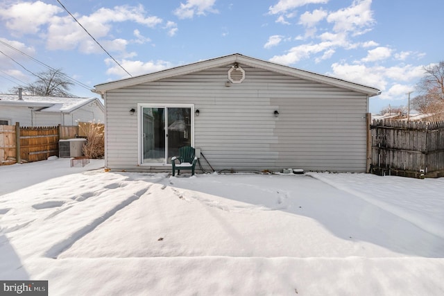 snow covered property with central AC