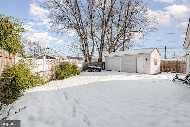 yard covered in snow with an outbuilding and a garage