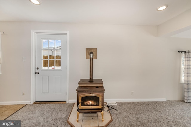 carpeted living room with a wood stove