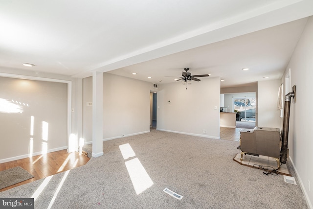 unfurnished living room featuring light colored carpet and ceiling fan