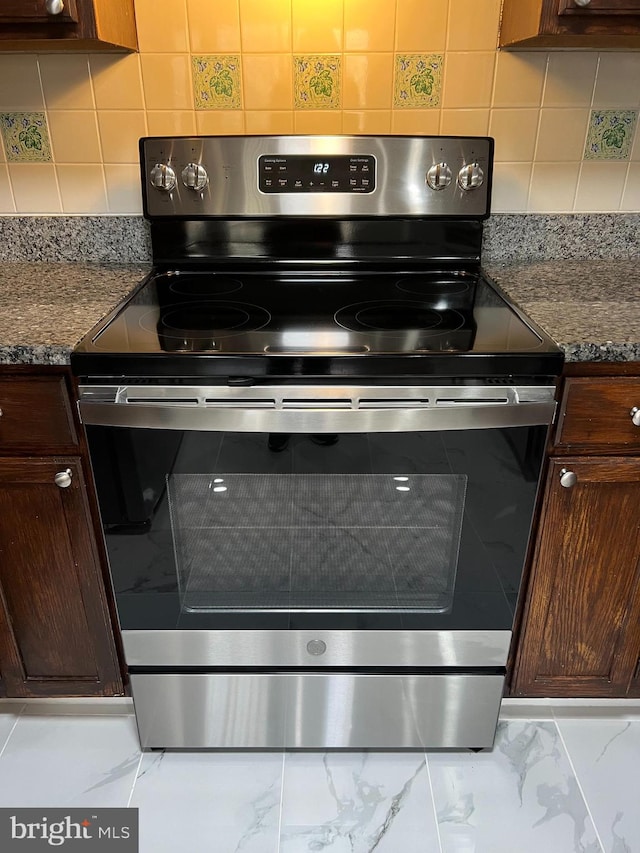 interior details featuring electric range, dark stone countertops, and backsplash