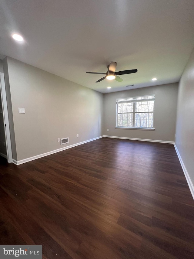 empty room with ceiling fan and dark hardwood / wood-style floors