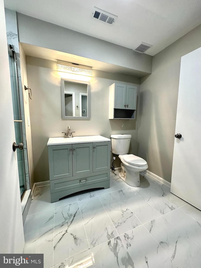 bathroom featuring vanity, toilet, and a shower with shower door