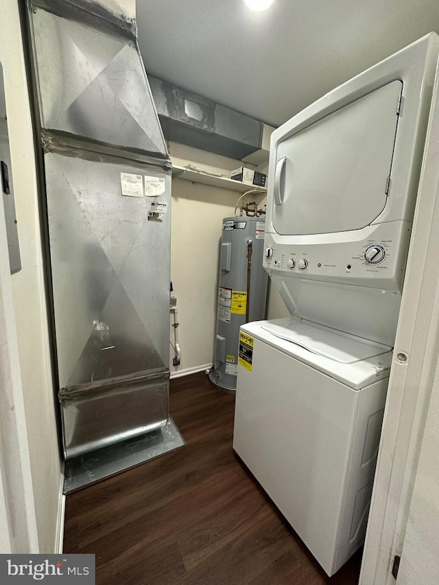 clothes washing area with stacked washer / dryer, electric water heater, dark hardwood / wood-style flooring, and heating unit