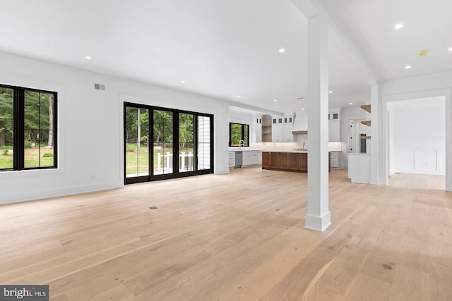 unfurnished living room featuring light hardwood / wood-style flooring and sink