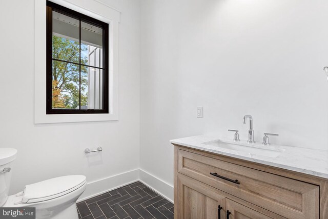 bathroom featuring tile patterned flooring, vanity, and toilet