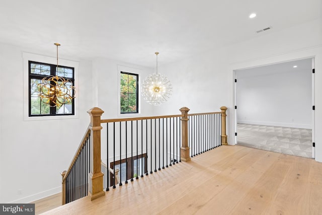 hallway featuring hardwood / wood-style floors and a notable chandelier