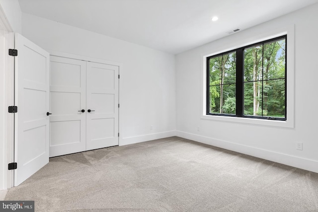 unfurnished bedroom featuring light carpet