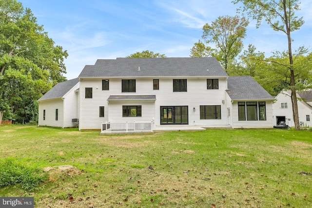 rear view of property with a patio and a lawn