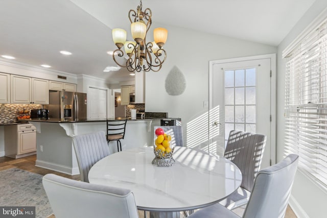 tiled dining room featuring lofted ceiling, crown molding, and an inviting chandelier