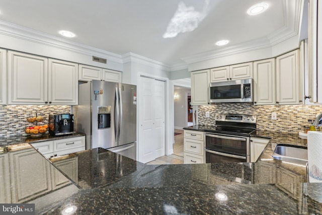 kitchen with appliances with stainless steel finishes, white cabinetry, ornamental molding, and sink