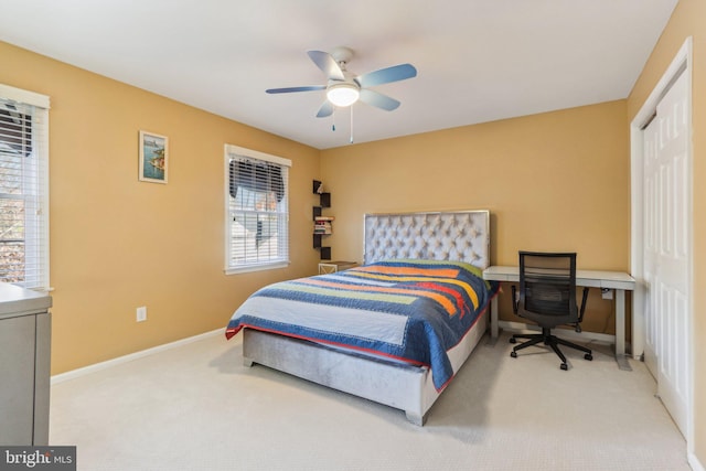 carpeted bedroom featuring multiple windows and ceiling fan