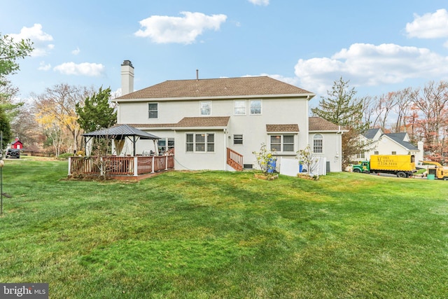 rear view of property featuring a gazebo and a lawn