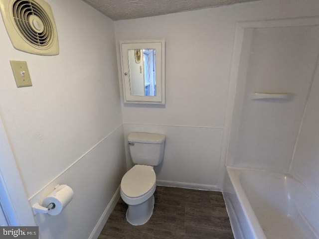 bathroom with hardwood / wood-style floors, a textured ceiling, and toilet