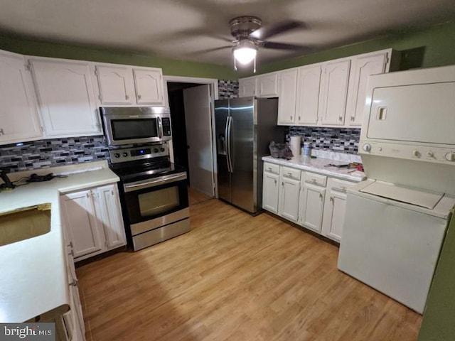 kitchen with white cabinets, stainless steel appliances, and stacked washer and clothes dryer