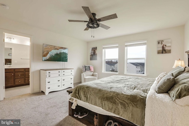 bedroom with ensuite bathroom, ceiling fan, and light carpet