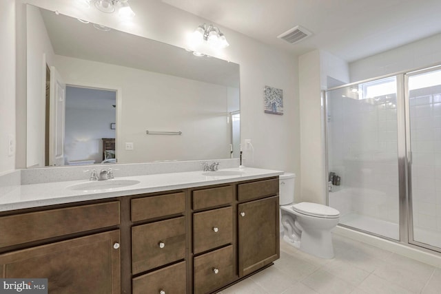 bathroom featuring tile patterned flooring, a shower with door, vanity, and toilet