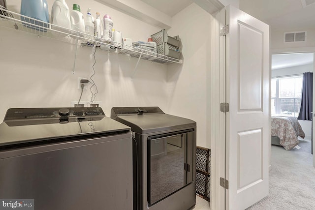 laundry room featuring light carpet and washing machine and clothes dryer