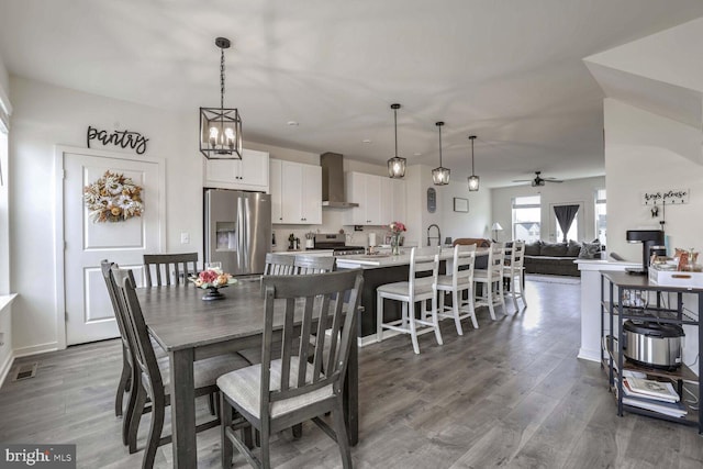 dining room featuring hardwood / wood-style floors and ceiling fan with notable chandelier