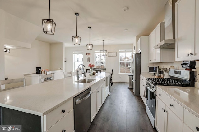 kitchen featuring dark hardwood / wood-style flooring, stainless steel appliances, sink, a center island with sink, and white cabinetry