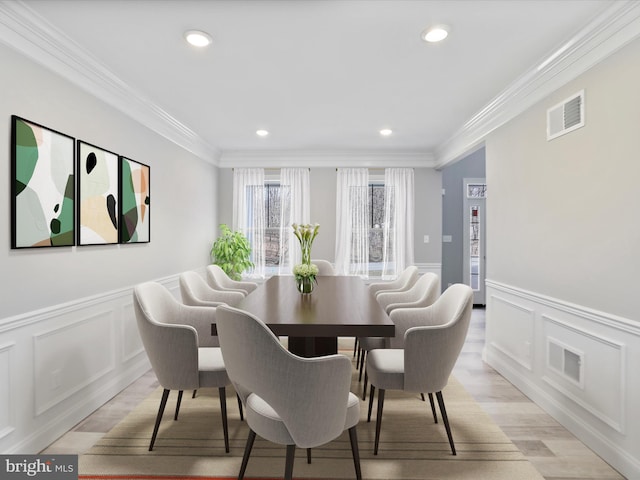 dining space with crown molding, recessed lighting, visible vents, and light wood finished floors