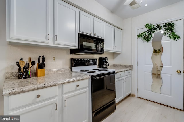 kitchen featuring light stone counters, light hardwood / wood-style flooring, white cabinetry, and black appliances