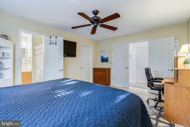 carpeted bedroom with ensuite bathroom and ceiling fan