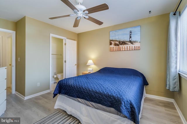 bedroom featuring ceiling fan, light hardwood / wood-style floors, ensuite bathroom, and multiple windows