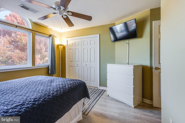 bedroom with ceiling fan, light hardwood / wood-style floors, and a closet