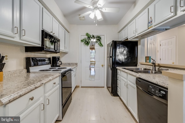 kitchen featuring ceiling fan, sink, white cabinets, black appliances, and light wood-type flooring