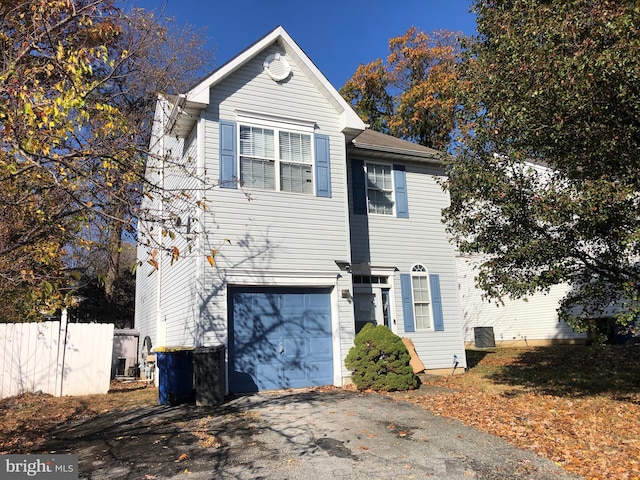 view of front of home with central AC unit and a garage