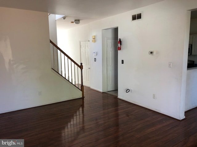 empty room with dark hardwood / wood-style flooring