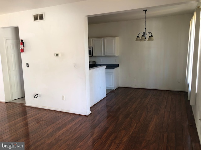 kitchen featuring an inviting chandelier, hanging light fixtures, and dark wood-type flooring