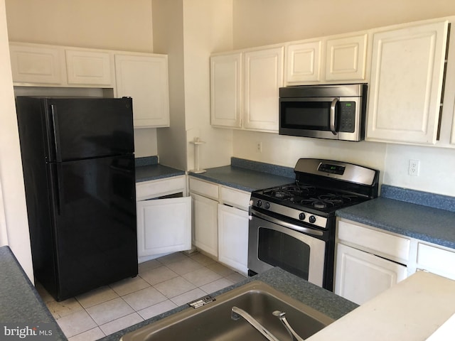 kitchen featuring sink, white cabinetry, stainless steel appliances, and light tile patterned floors