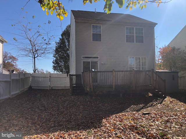 rear view of house featuring a wooden deck