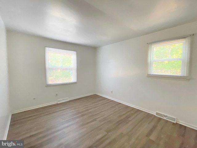 empty room with wood-type flooring and a wealth of natural light