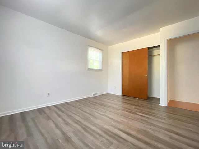 unfurnished bedroom with a closet and light wood-type flooring