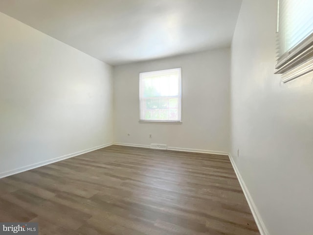 spare room featuring dark wood-type flooring