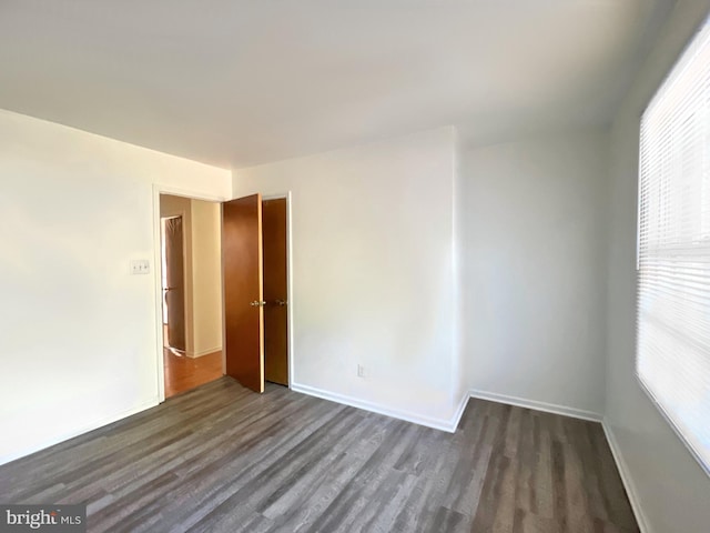 spare room with dark hardwood / wood-style floors and a wealth of natural light