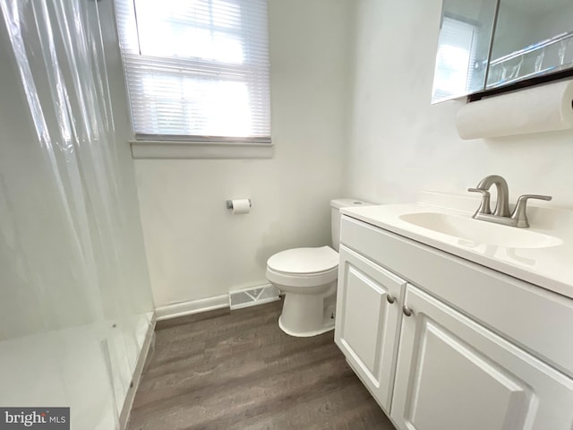 bathroom featuring a shower with curtain, vanity, wood-type flooring, and toilet