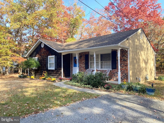 single story home with covered porch and a front yard