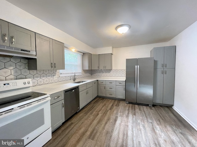 kitchen featuring decorative backsplash, stainless steel appliances, dark hardwood / wood-style floors, and ventilation hood