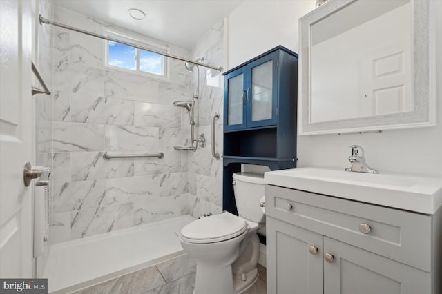 bathroom featuring tile patterned flooring, vanity, toilet, and a tile shower