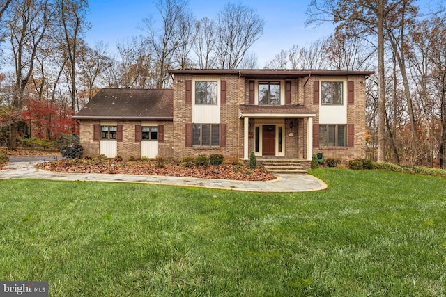 view of front of house with a front yard and brick siding