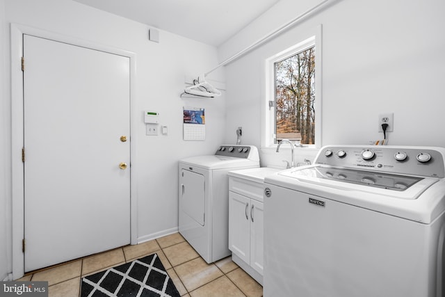 laundry room with washer and dryer, cabinet space, a sink, and light tile patterned flooring