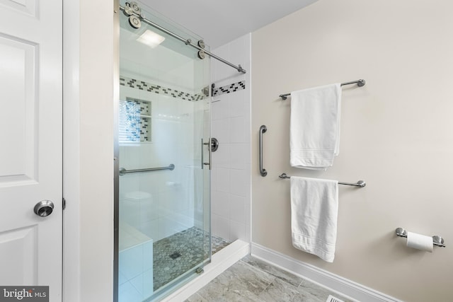 bathroom featuring a stall shower and baseboards