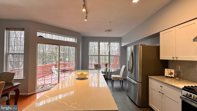 kitchen with white cabinets, hanging light fixtures, and a healthy amount of sunlight