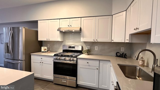 kitchen with backsplash, sink, dark tile patterned floors, appliances with stainless steel finishes, and white cabinetry