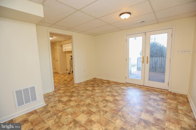 spare room featuring a paneled ceiling and french doors